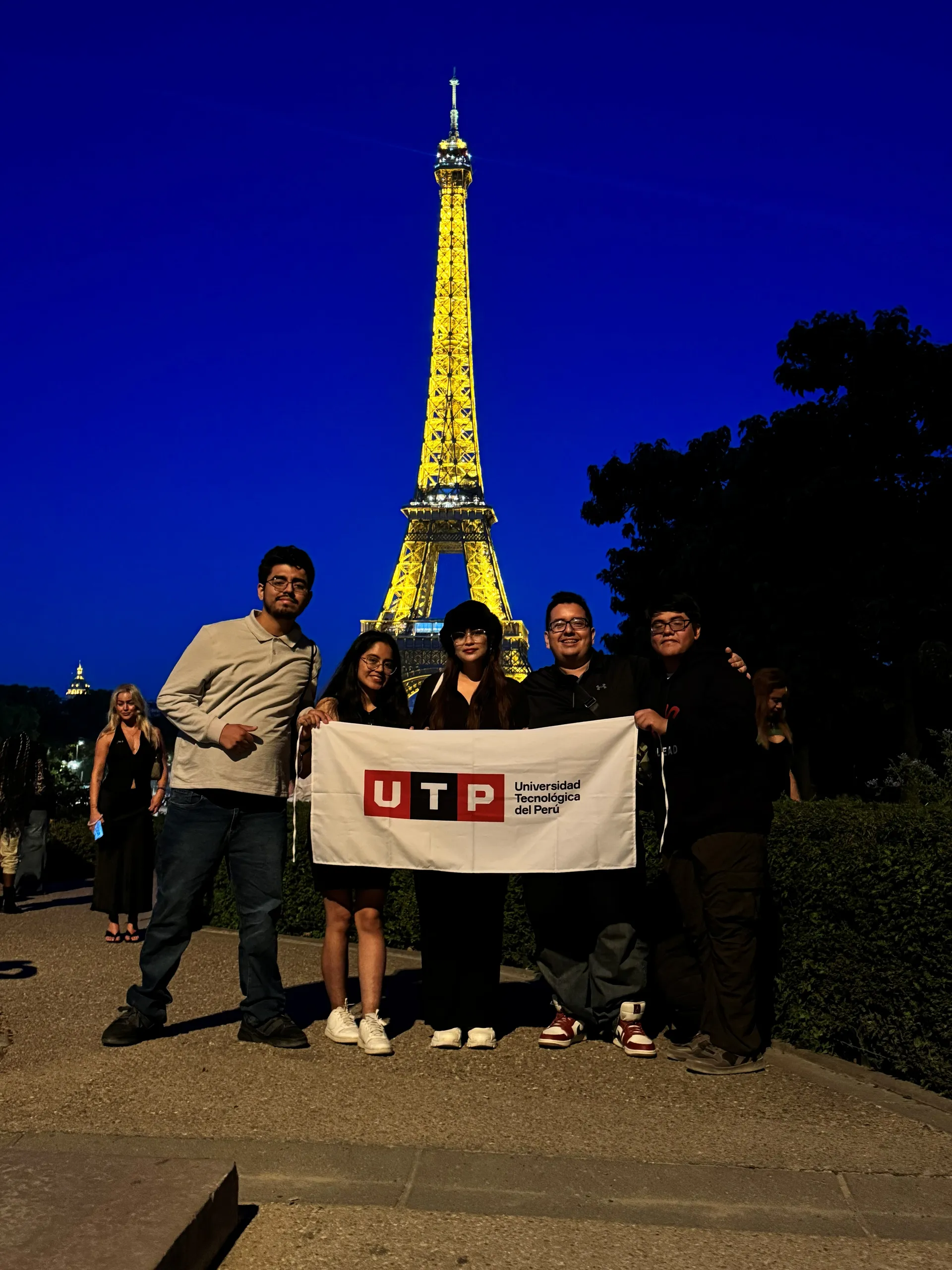Delegación de LEAD UTP con la bandera de la UTP frente a la Torre Eiffel, en RAISE Summit Hackathon, Francia