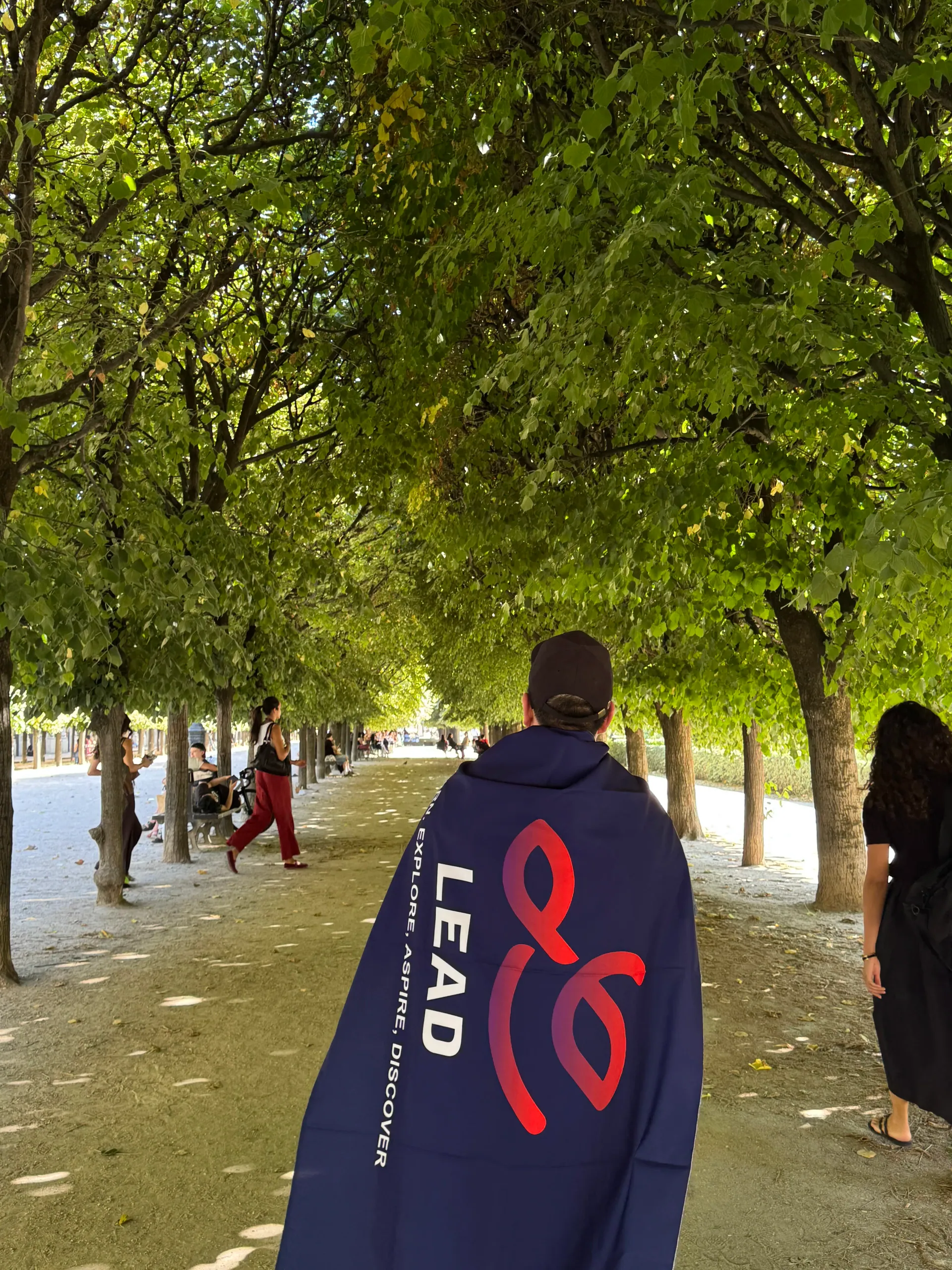 Integrante de LEAD UTP con la bandera de LEAD en los jardines de París, durante RAISE Summit Hackathon, Francia